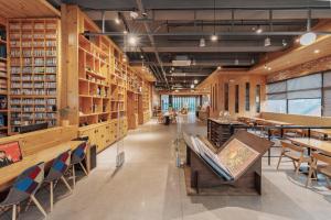 a library with wooden shelves and tables and chairs at Jeonju Yeonghwa Hotel in Jeonju
