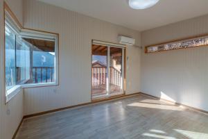 an empty room with a large window and a balcony at Hwasun Byeolsan Pension in Wajun