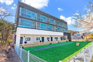 a large building with a lawn in front of it at Glamdog Dog Pension Yeongheungdo Branch in Pŏdŏni
