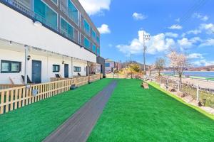 a large yard with green grass in front of a building at Glamdog Dog Pension Yeongheungdo Branch in Pŏdŏni +25 photos