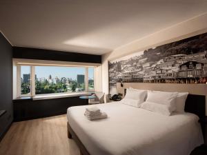 a bedroom with a large white bed with a large window at Novotel Santiago Vitacura in Santiago +194 photos