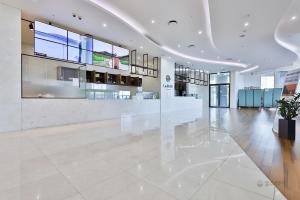 Un amplio vestíbulo con un gran suelo blanco y paredes de cristal. en Hotel The PORA Suitz, en Sodong-ni