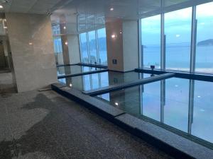 una piscina en un edificio con ventanas de cristal en Hotel The PORA Suitz, en Sodong-ni