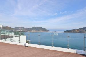 un balcón con vista al agua en Hotel The PORA Suitz, en Sodong-ni