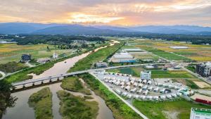 an aerial view of a river with a bridge at Gangneung Base Camp Caravan Glamping in Hwapyeong-dong