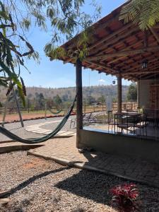 a hammock in a pavilion with a table and chairs at Pousada Flat Royal - Flat 03 in Itapecerica