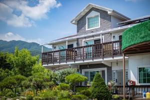 a house with a balcony with a green roof at Glamdog Dog Pension Gapyeong Branch in Gapyeong