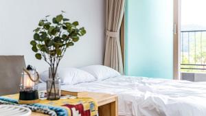 a bedroom with a bed and a table with a vase at Glamdog Dog Pension Tongyeong Branch in Wŏnmul-li