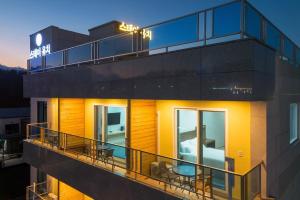 a building with a balcony with tables and chairs at Sokcho Stay Ongchi in Puwŏl-li