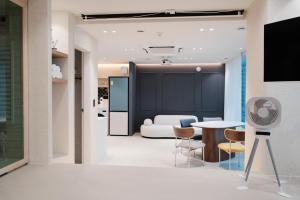 ein Wohnzimmer mit einer weißen Couch und einem Tisch in der Unterkunft Cinnamon Stay Gwangan in Millak-tong