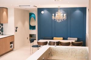 eine Küche mit einer blauen Wand und einem Kronleuchter in der Unterkunft Cinnamon Stay Gwangan in Millak-tong + 1 Foto