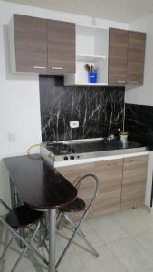 a kitchen with a counter and a table with chairs at Confortable apartamento vacacional in Ricaurte