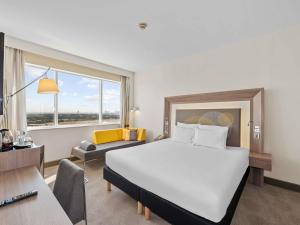 Una habitación de hotel con una cama grande y un escritorio. en Novotel Dubai World Trade Centre, en Dubái