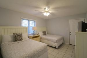 a bedroom with two beds and a ceiling fan at Madelyn's Oceanview in Tybee Island