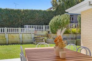 a wooden table with a vase on top of it at 4BR Torquay Retreat with Serene Views in Torquay