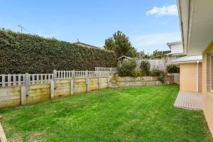 a backyard with a fence and green grass at 4BR Torquay Retreat with Serene Views in Torquay