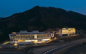 a building with lights on in front of a mountain at Take Hotel & Resort Inje Speedium in Inje +70 photos