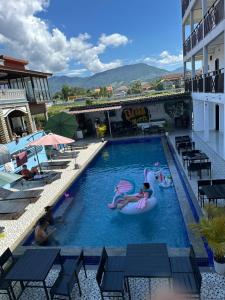 a pool at a hotel with people in a raft in it at Santara Hostel in Vang Vieng
