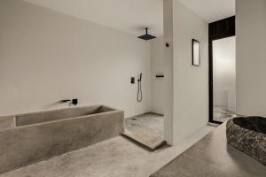 Casa laak'o 'ob en La Veleta في تولوم: حمام مع حوض استحمام خرساني كبير في الغرفة +16 صورة