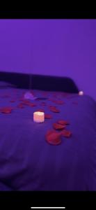 un letto viola con una candela sopra di Studio détente Spa et hammam a Toulouges