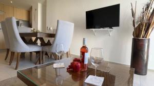 ヌエボ・バジャルタにあるBeach apartment 6px, Nuevo Vallarta Ocean Viewのワインのボトルが置かれたガラスのテーブルがあるリビングルーム