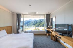 a hotel room with a bed and a large window at Take Hotel & Resort Inje Speedium in Inje