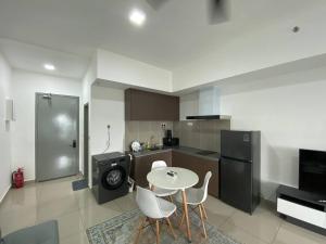 Una cocina con mesa y sillas y un refrigerador. en Alinea BlueView Suites, en Shah Alam