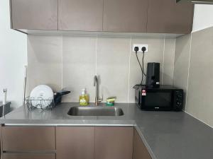 een aanrecht met een spoelbak en een magnetron bij Alinea BlueView Suites in Shah Alam