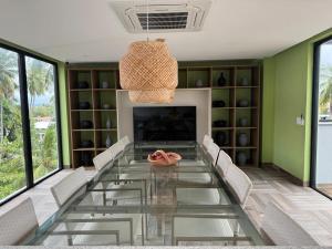 een eetkamer met een glazen tafel en stoelen bij Mar de Campas - Tamandaré 016 in Tamandaré