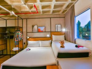 two beds in a small room with a window at ibis Sao Paulo Morumbi in Sao Paulo +66 photos