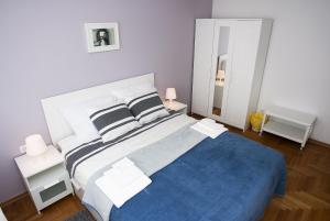 a bedroom with a large bed with a blue blanket at Paw Rooms in Zagreb