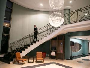 a man walking down a staircase in a building at Mercure Sao Caetano do Sul in São Caetano do Sul