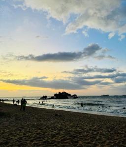 a group of people on the beach at sunset at Apartamento praia do farol in Mosqueiro