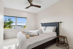 a bedroom with a bed with a large window at Sapphire Magic. in Urunga