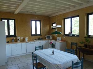 Una cocina con una mesa con un jarrón encima. en Charmant Gîte avec Cheminée et Animaux Admis - FR-1-496-31, en Saint-Haon-le-Vieux