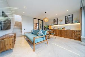 a living room with a blue couch and a table at Townhouse T1 - Hidden Gem in Ubud -Townhouse in Ideal Location in Ubud