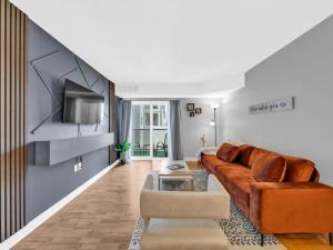 a living room with a couch and a tv at Rare find by the Riverside in Windsor