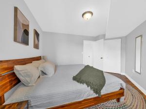 a bedroom with a large bed with white walls at Rare find by the Riverside in Windsor