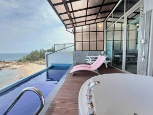 a bathroom with a bath tub and a view of the ocean at Yeongdeok Searest Pool Villa in Changsa-ri