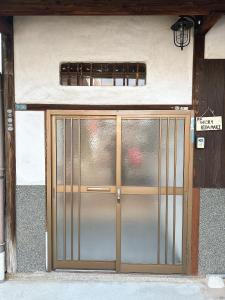 ajar door of a building with a metal gate at 民宿ひだまり Minsyuku Hidamari in Kurashiki