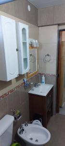 a bathroom with a sink and a toilet and a mirror at Casa Elena - Reta in Reta