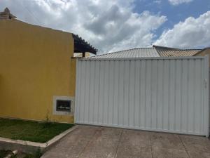 un garage blanc à côté d'un bâtiment dans l'établissement Casa de praia em Cabo Frio, à Cabo Frio