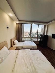 a hotel room with two beds and a large window at Thoth pyramids view hotel in Cairo