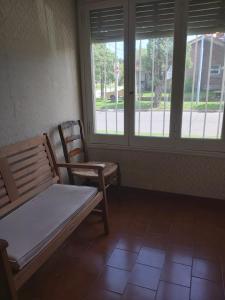 a bench and a chair in a room with windows at Casa En Punta Mogotes in Mar del Plata