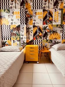 a bedroom with two beds and a wall with a mural at AP localização é tudo Pitangueiras in Guarujá