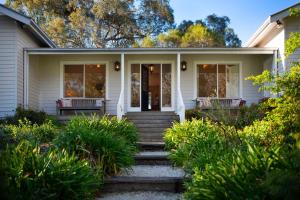 een wit huis met een veranda en een trap bij Casa Adagio in Daylesford