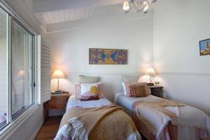 twee bedden in een witte kamer met een raam bij Casa Adagio in Daylesford