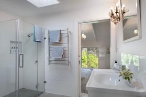 een witte badkamer met douche en wastafel bij Casa Adagio in Daylesford +15 foto's