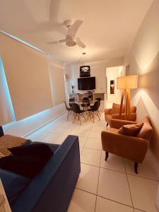 a living room with a couch and chairs and a table at AP localização é tudo Pitangueiras in Guarujá +68 photos