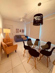 a living room with chairs and a table and a couch at AP localização é tudo Pitangueiras in Guarujá